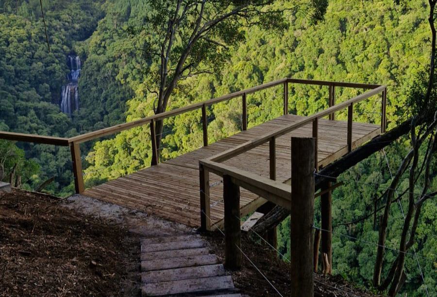 Trilha em meio à natureza com vista para mirante